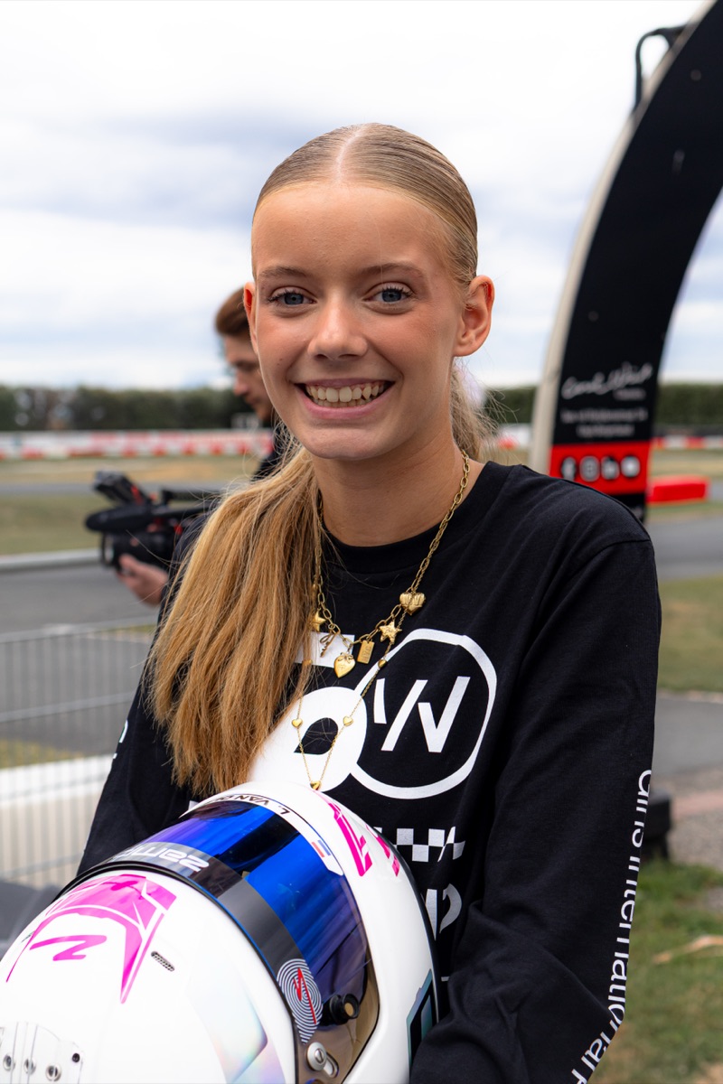 Lotte lachend met haar helm in de paddock