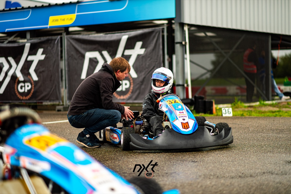 Lotte overlegt in de pitlane over de afstelling van de kart