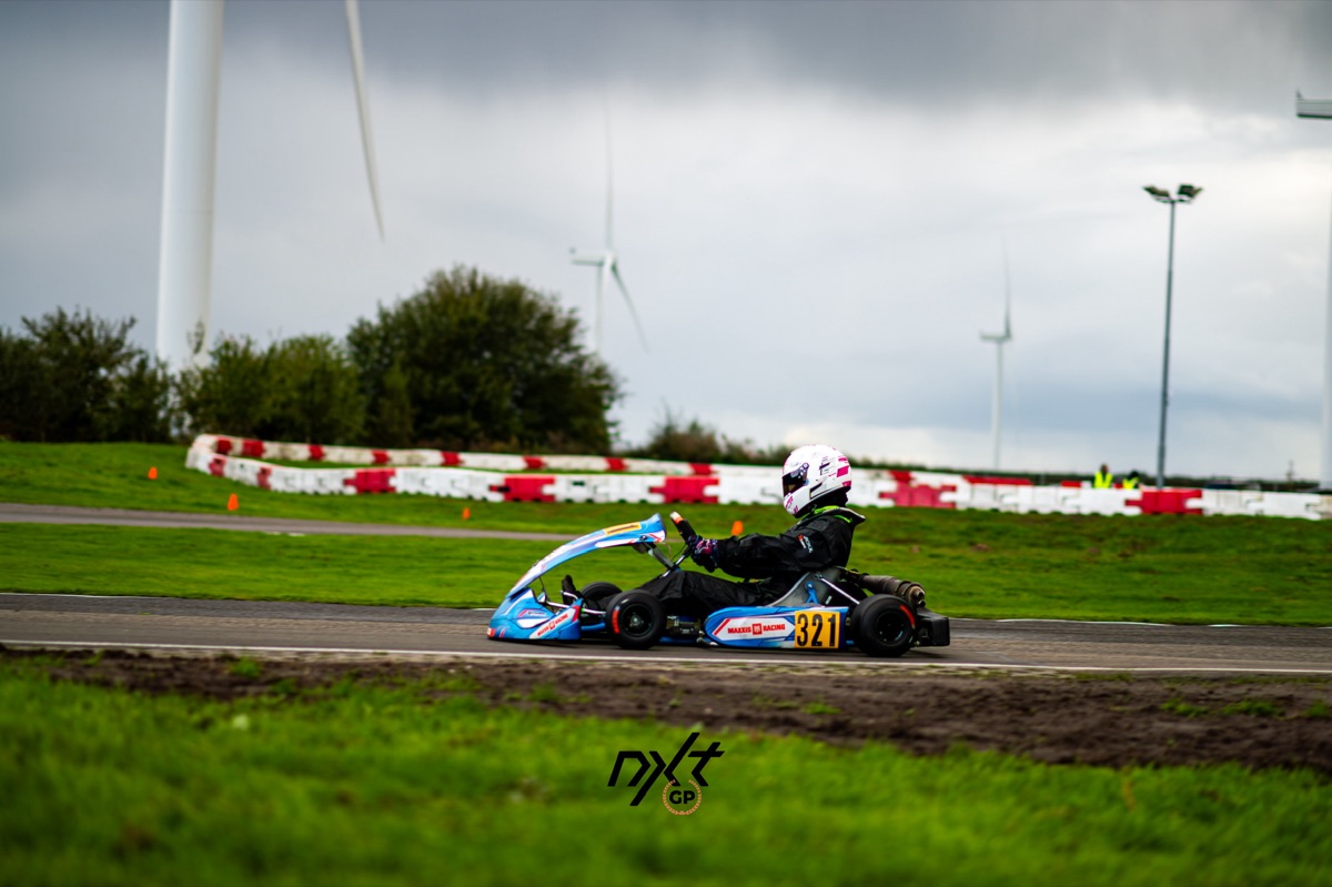 Lotte op het circuit van Karting Emmen, met windmolens op de achtergrond